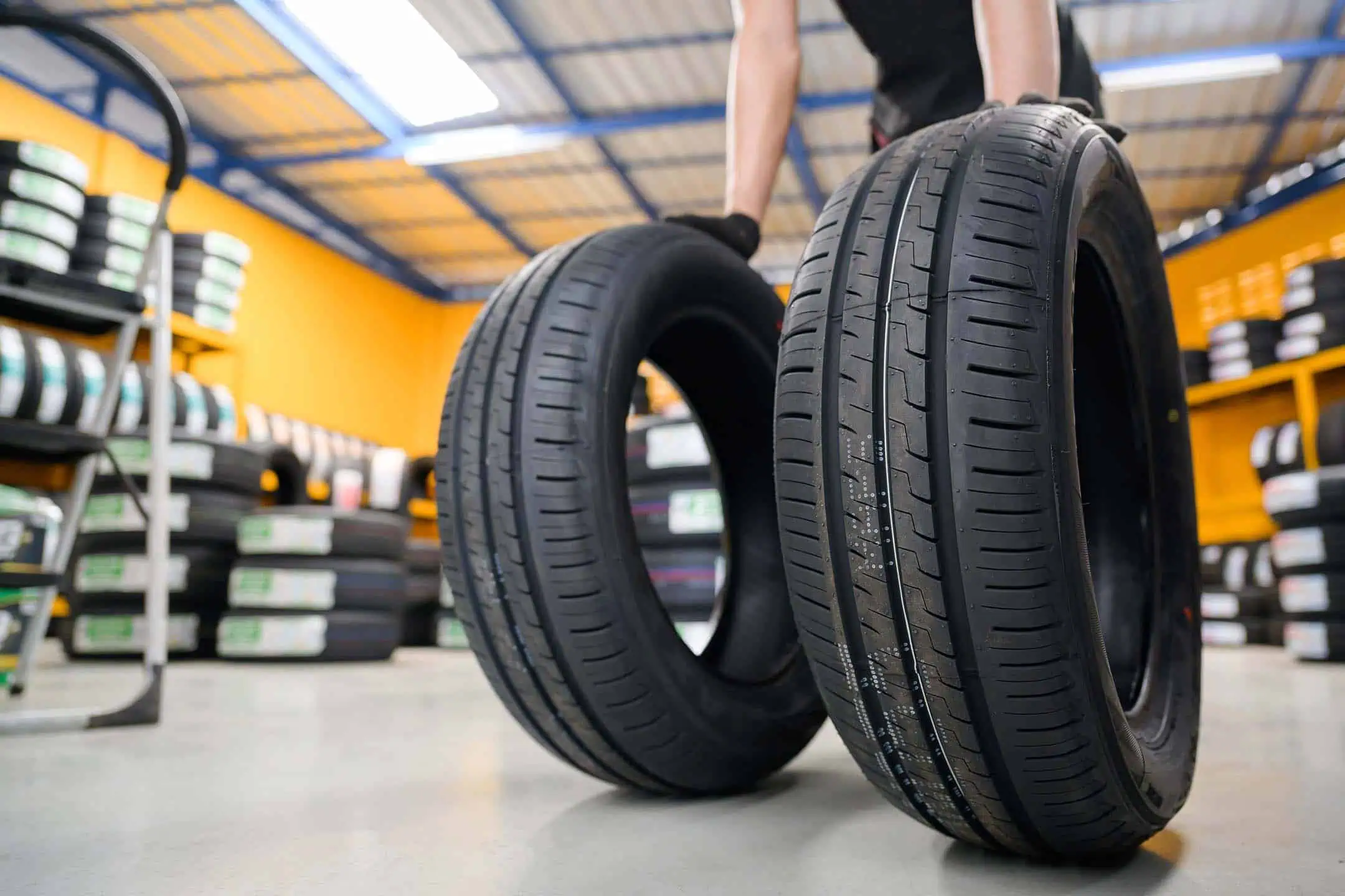 Mechanic Rolling Two Tyres