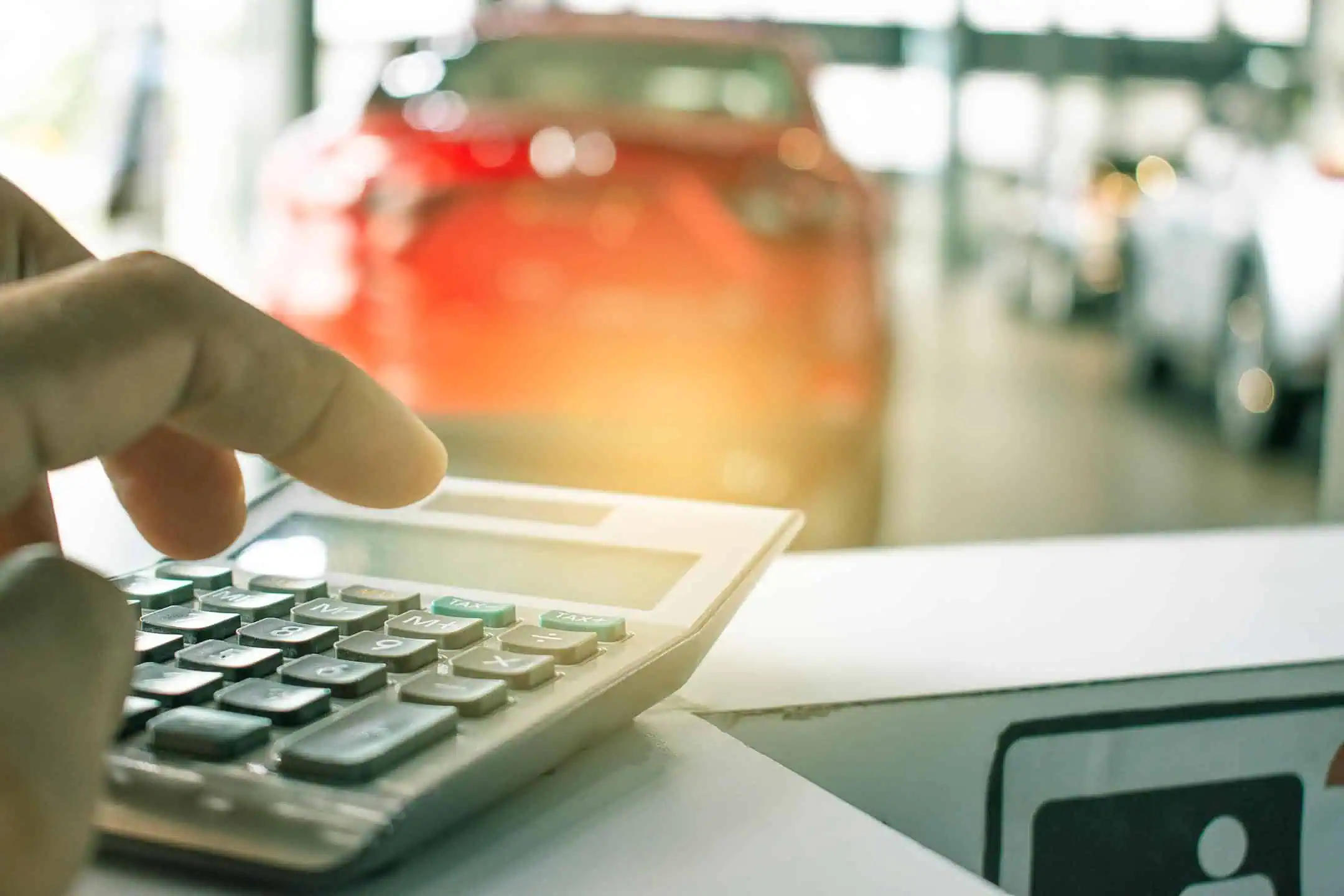 Close Up Of Man Using Calculator In Car Showroom