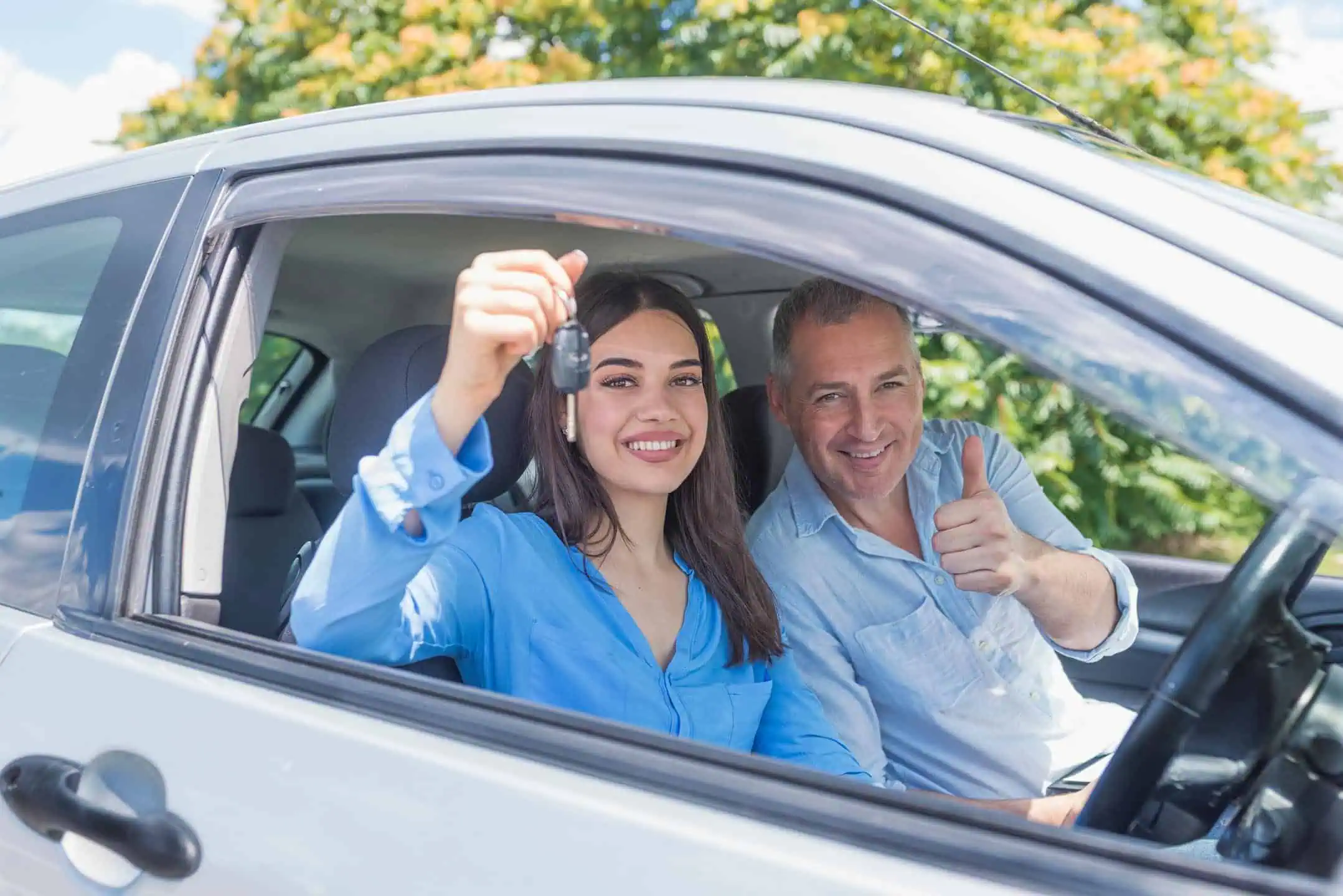 Girl Showing Car Keys With Instructor Next To Her