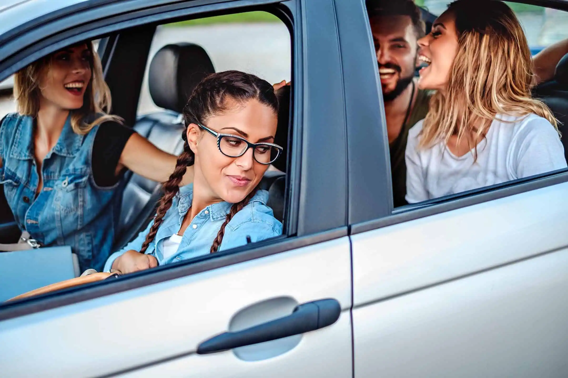 Group Of 4 Young People Laughing In A Car