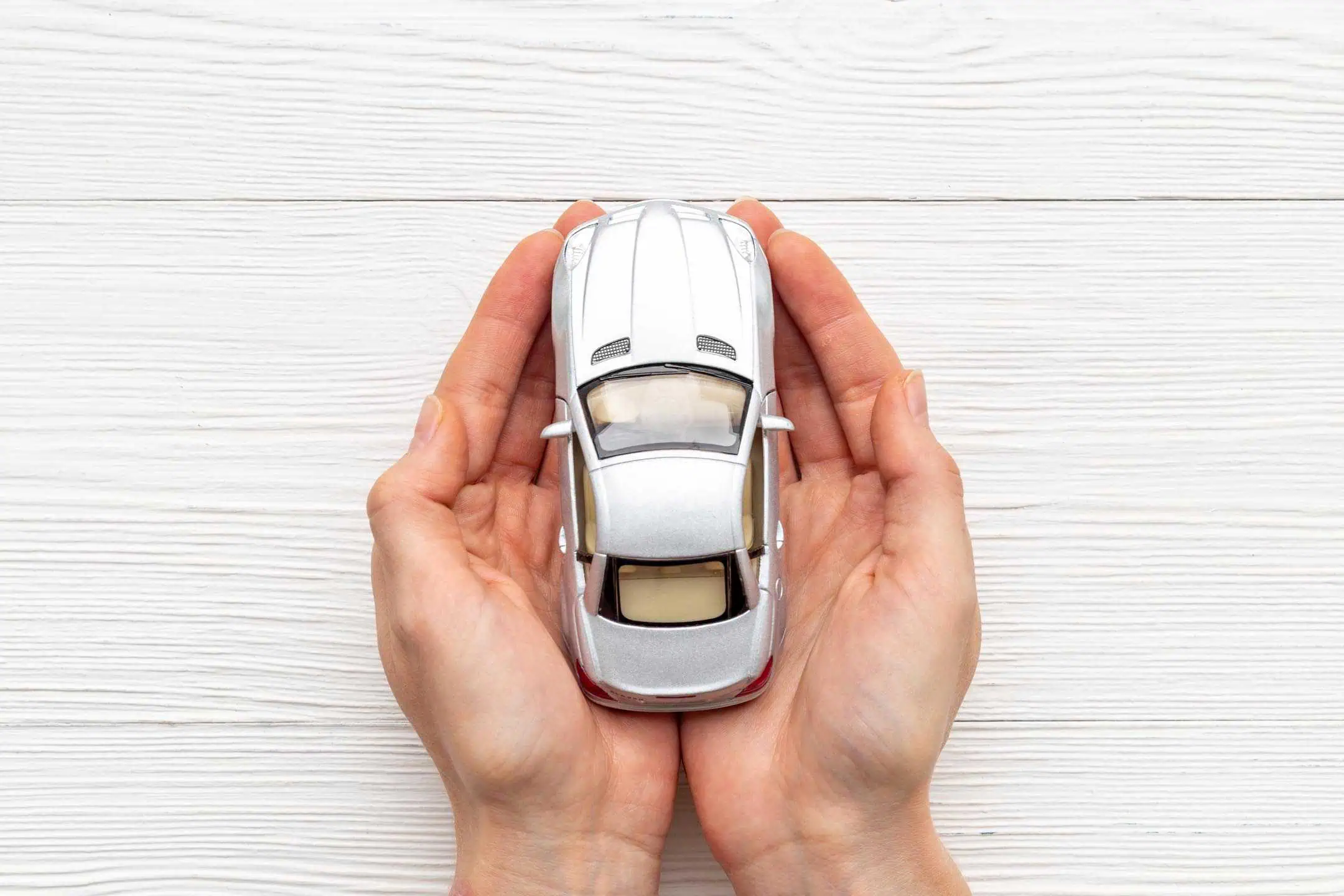 Hands Cradling Silver Toy Car