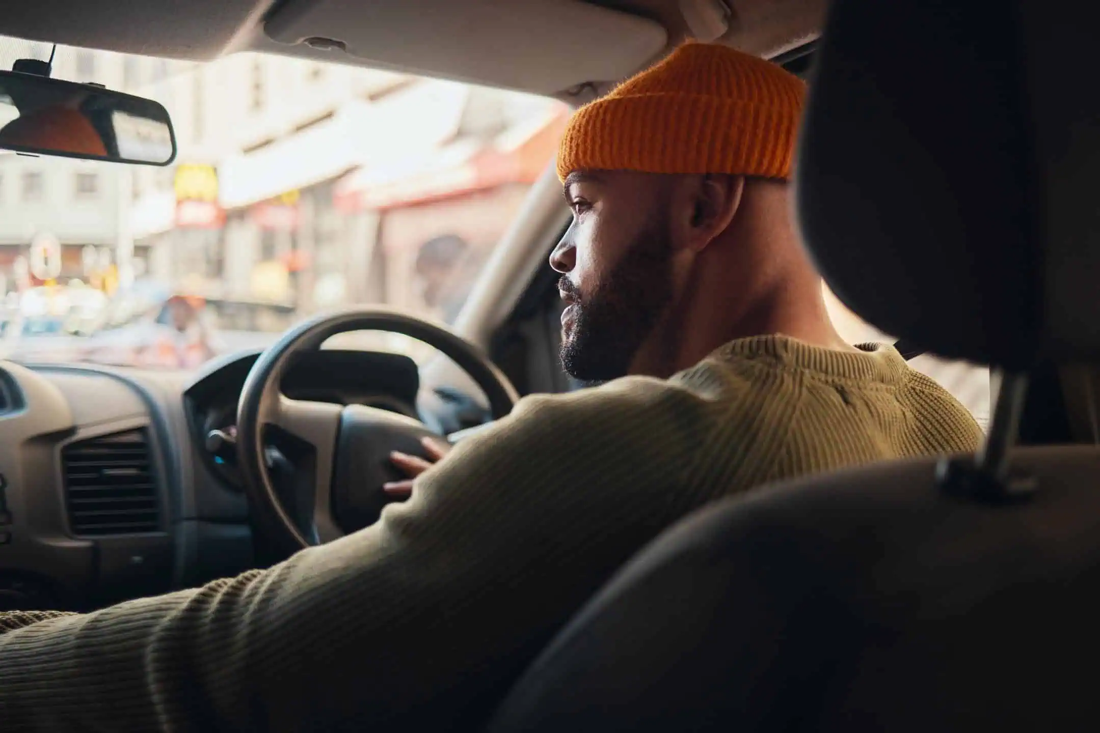 Man Behind Wheel Of Car Wearing Beanie Hat