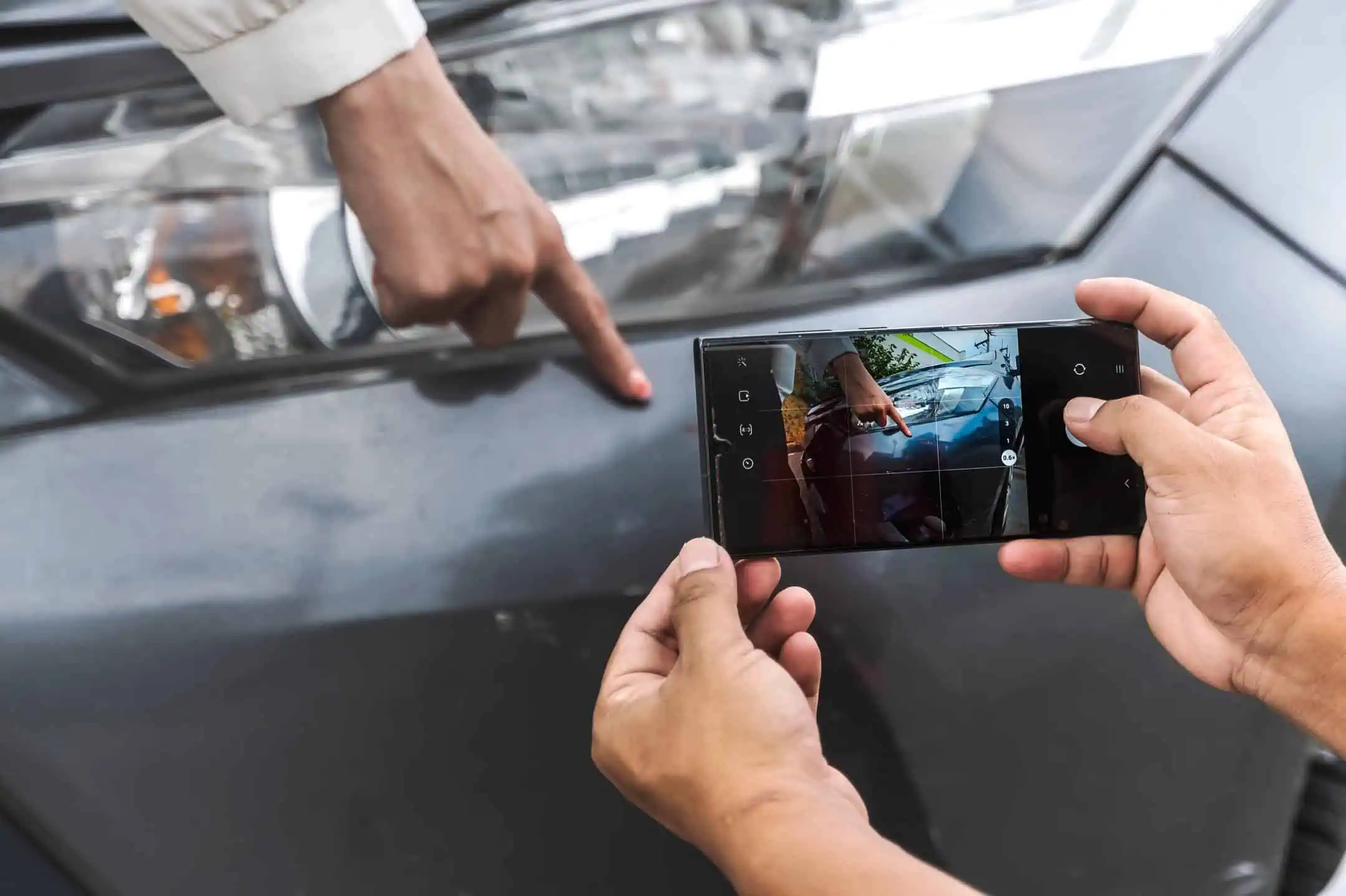 Man Holding Camera Taking Photo Of Car Damage