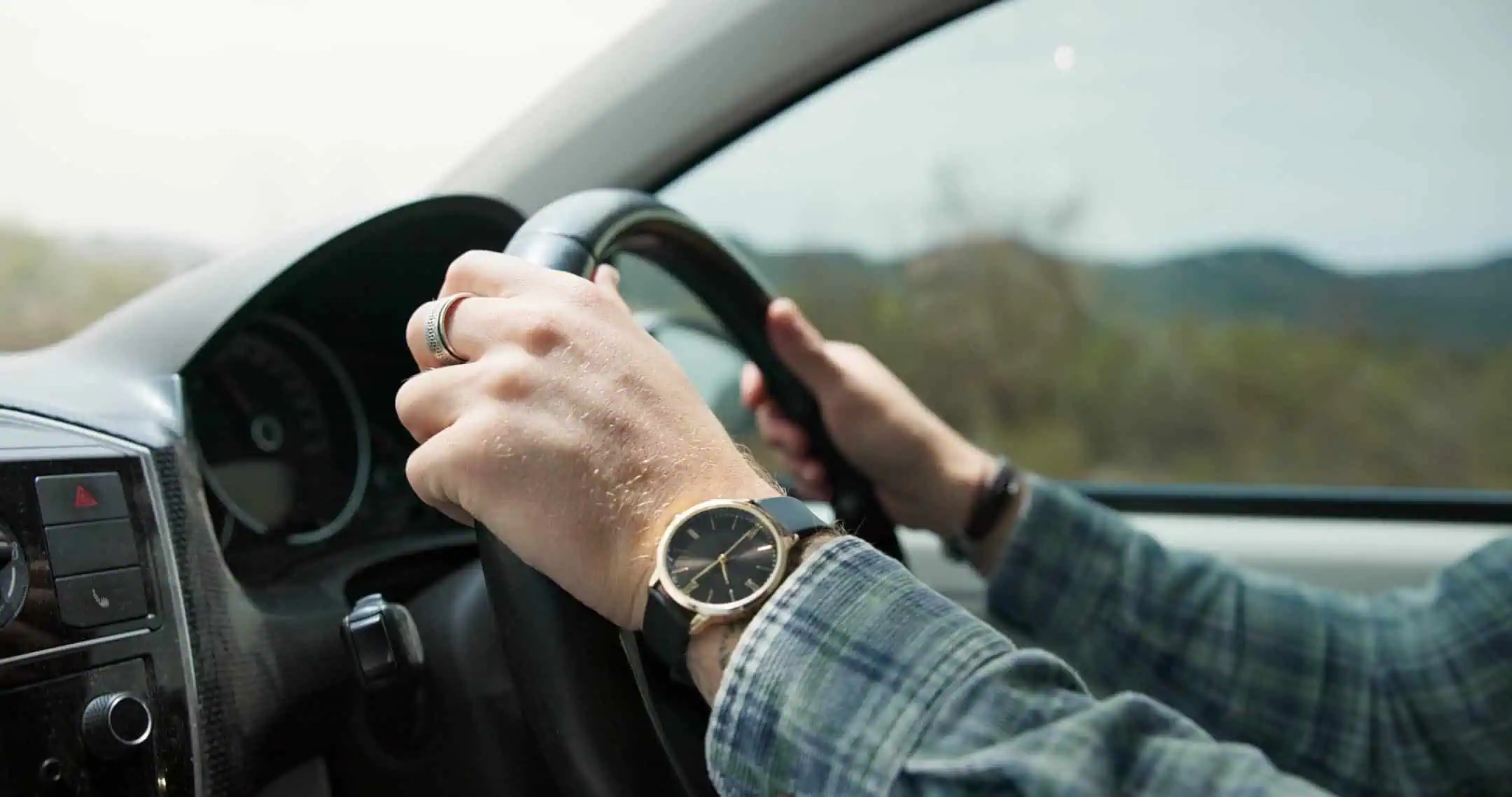 Mans Hands On The Steering Wheel Of A Car