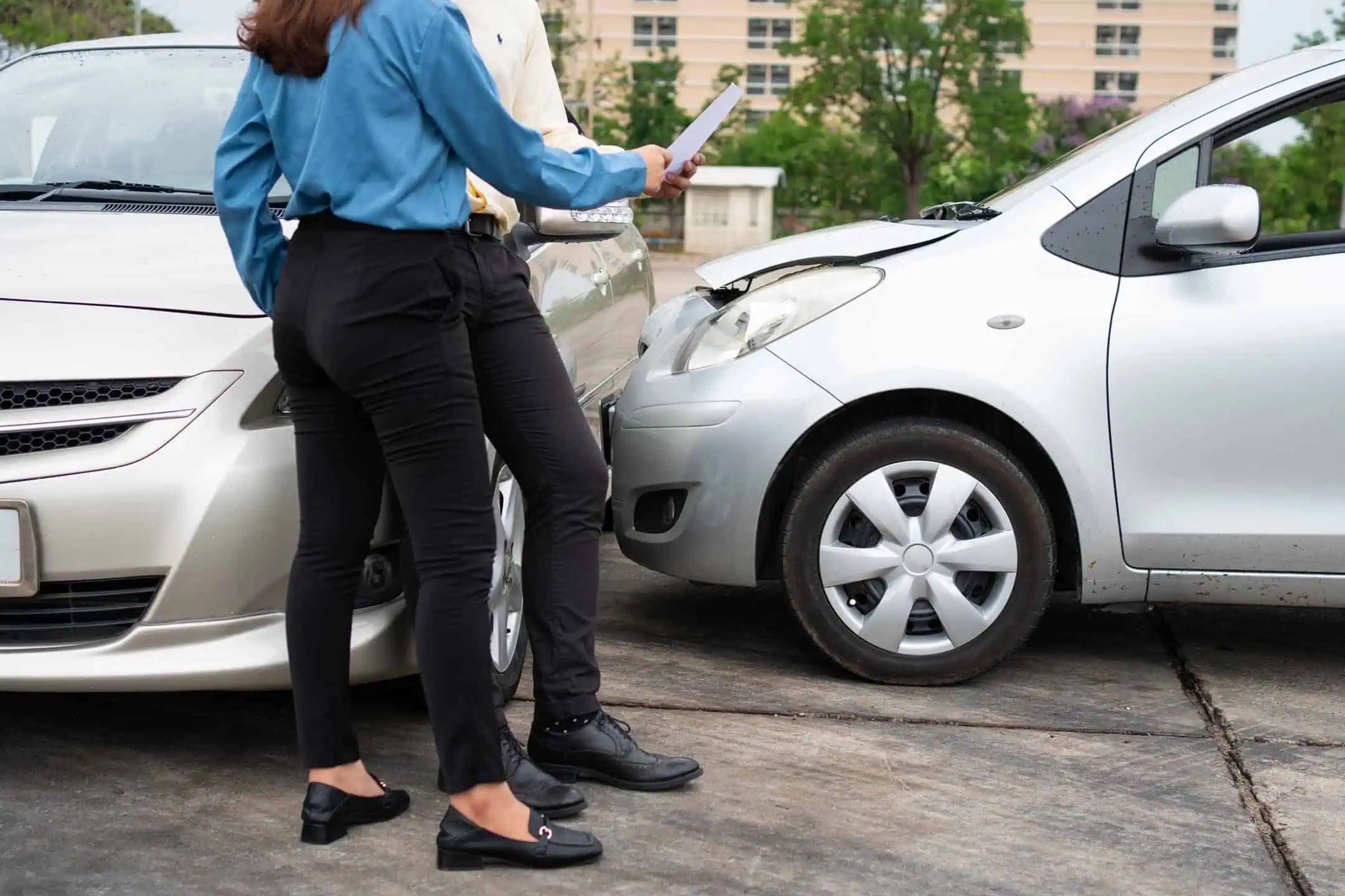 People Exchanging Information Car Crash Behind Them