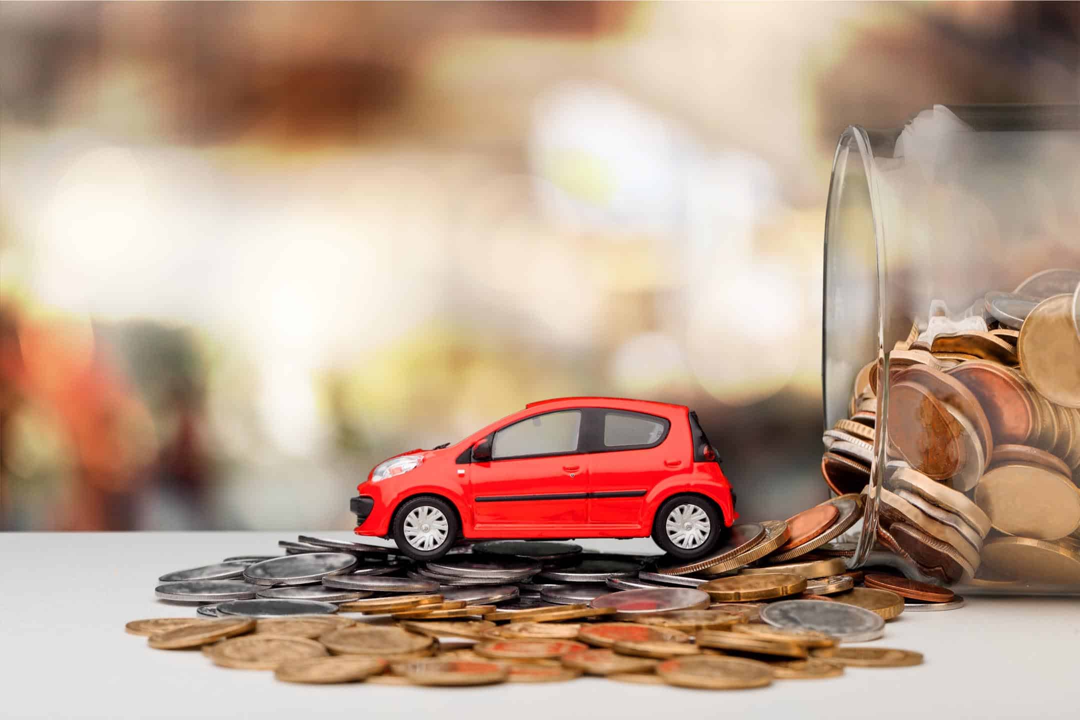 Red Toiy Car Coming Out Of A Jar Filled With Coins