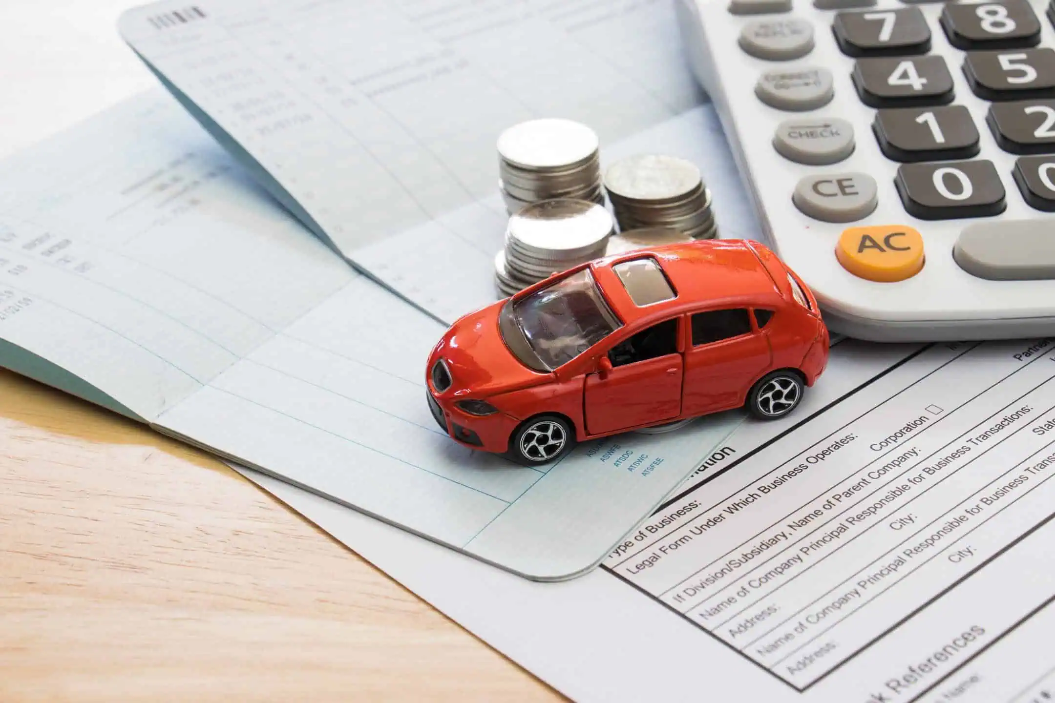 Red Toy Car Next To Calculator And Coins On A Form