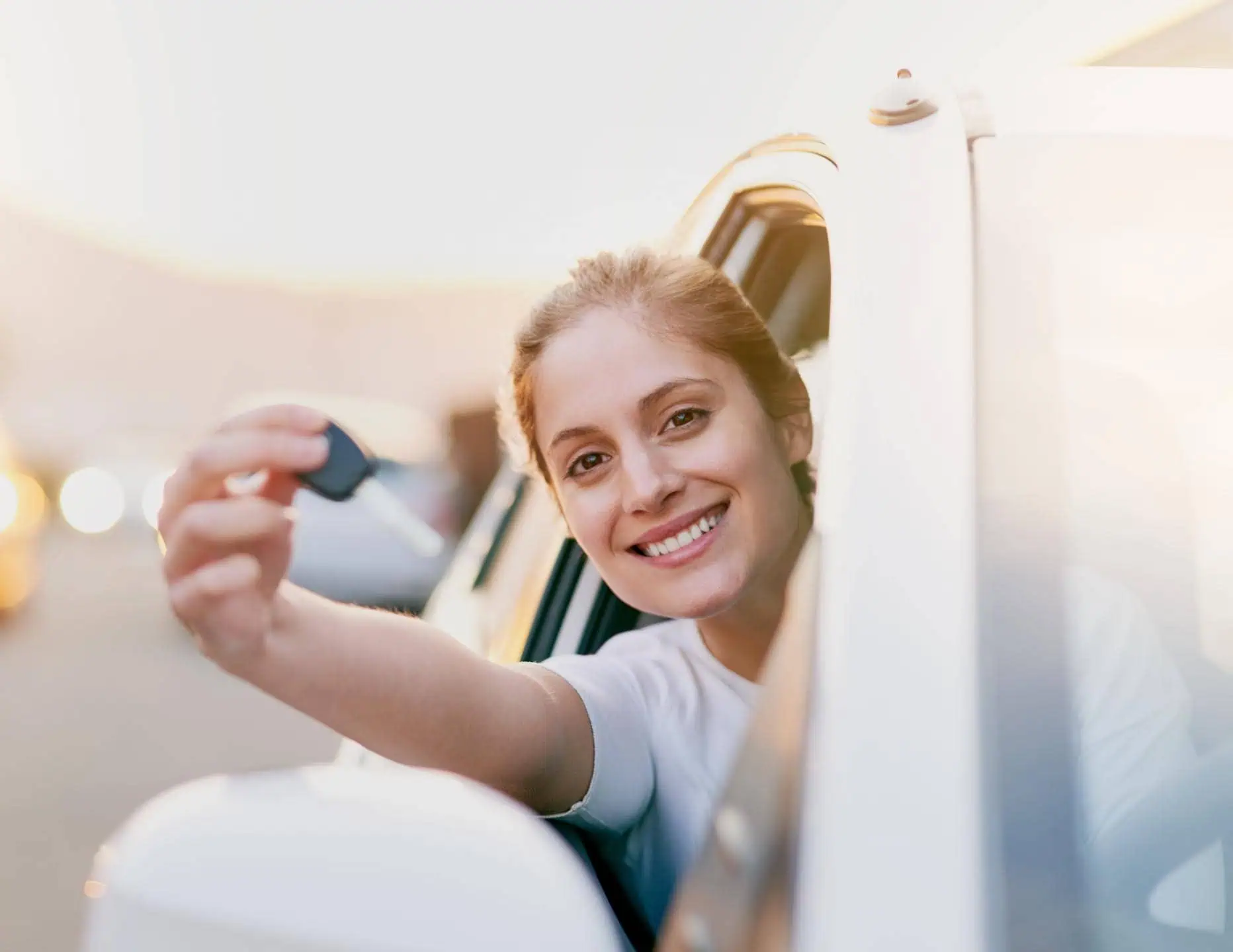 Smiling Woman Holding Keys Out Of Drivers Window