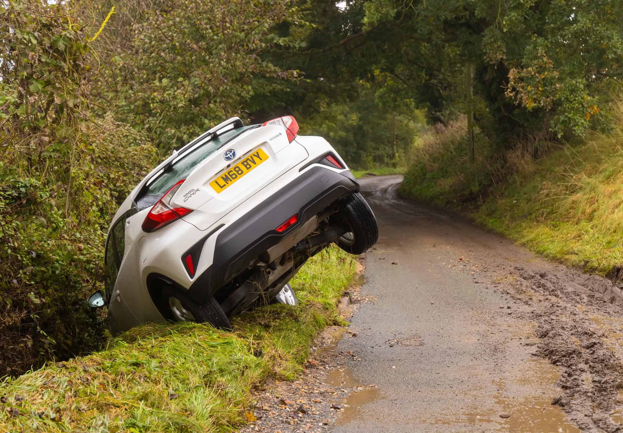 White Car In Ditch On Country Lane