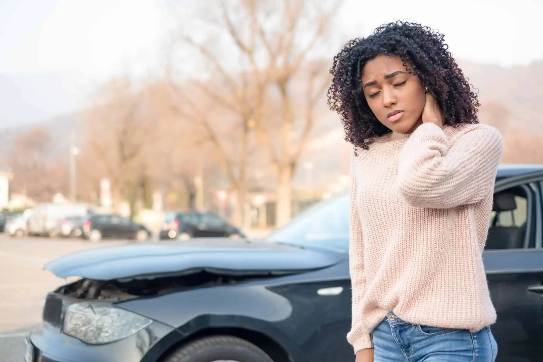 Woman Standing Outside Of Car With Whiplash